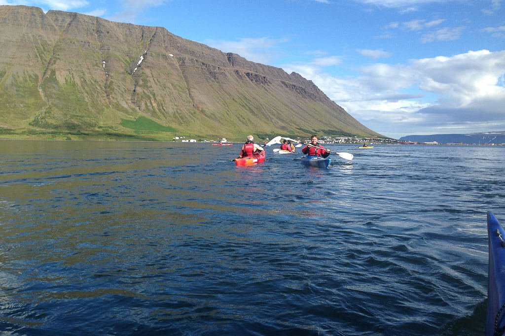 Kayakers On Water With Big Hill In The Background in Iceland