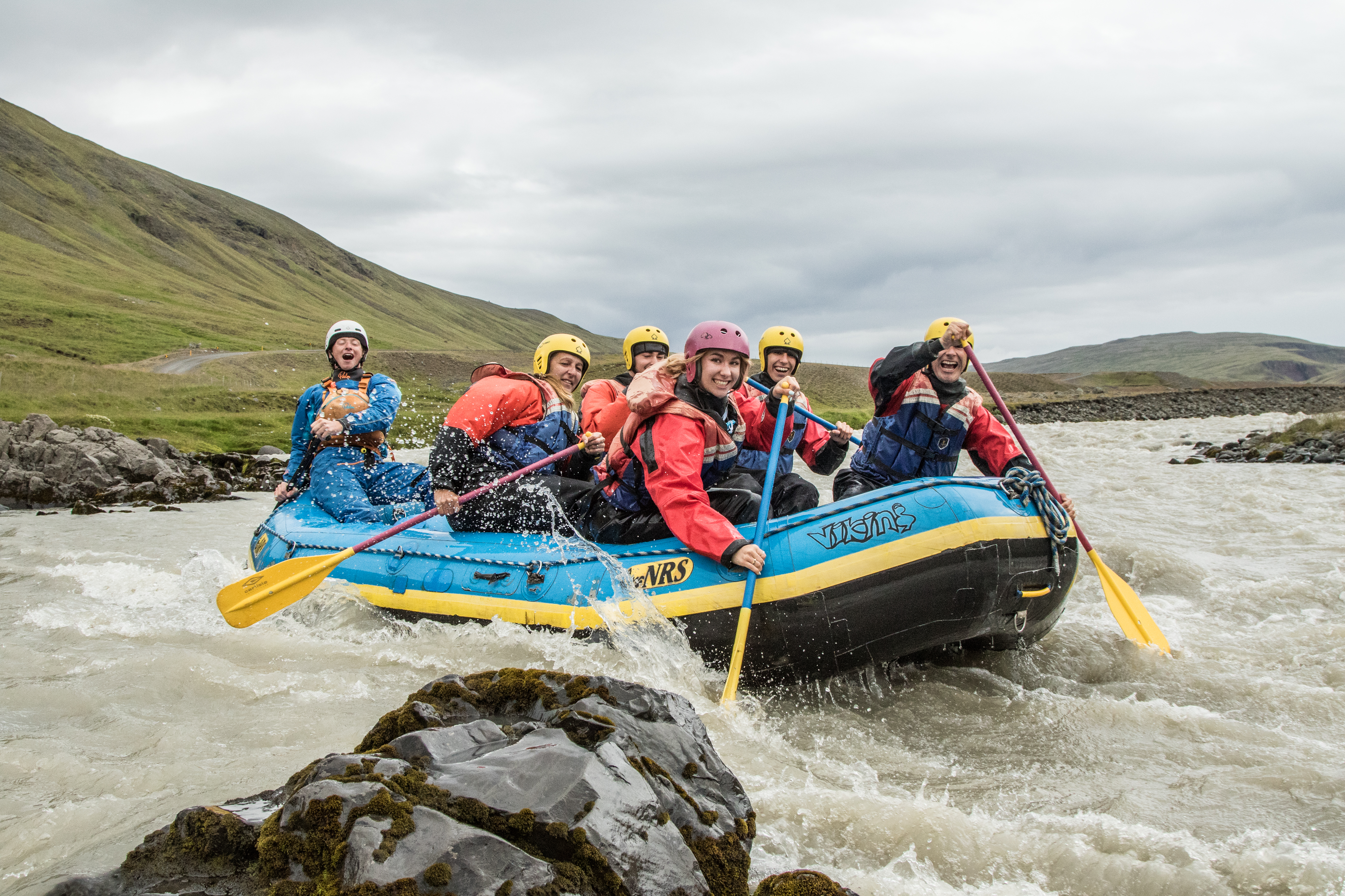 Group Of People In A Blue Boat River Rafting in Iceland