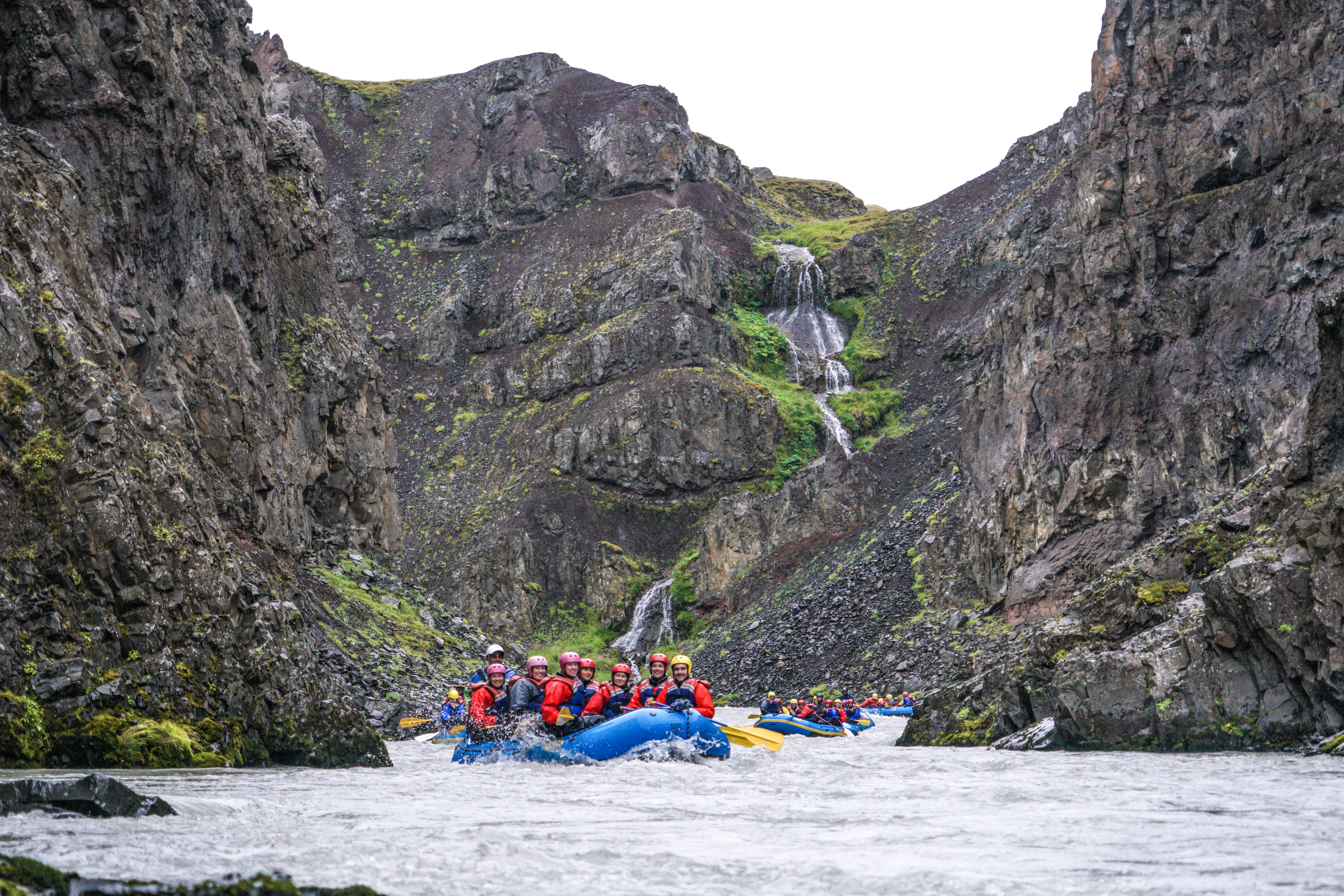 Groups Of People In Blue Boats White Water Rafting in Iceland