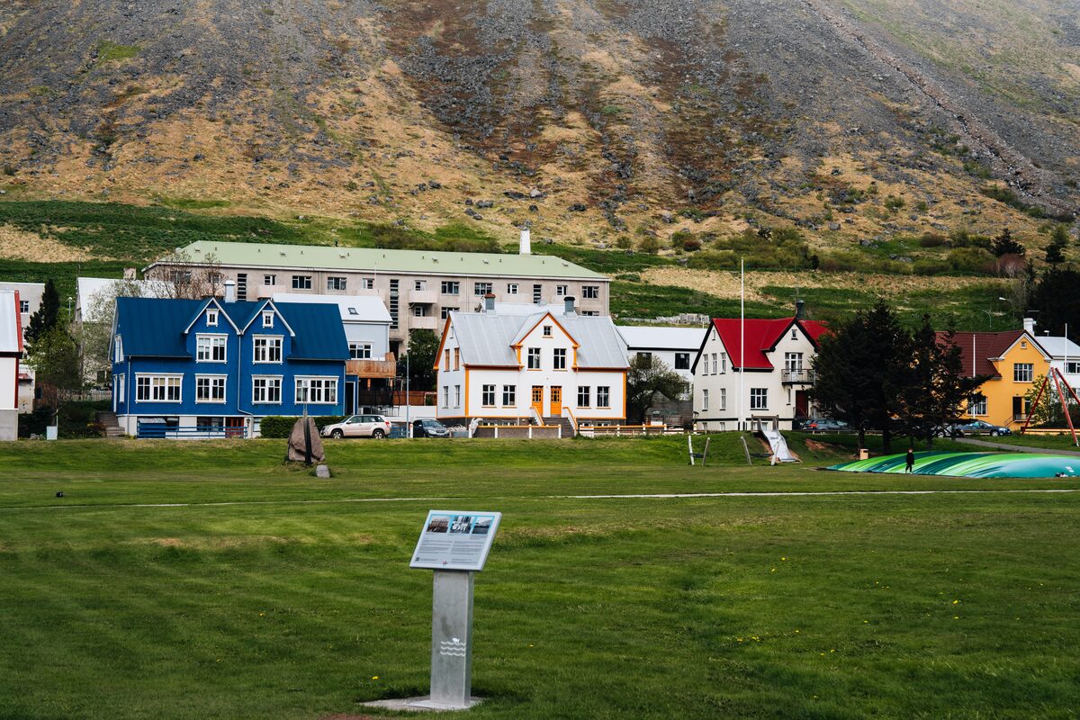 Colorful timber houses below a steep scree mountain in Ísafjörður, in Iceland's Westfjords.