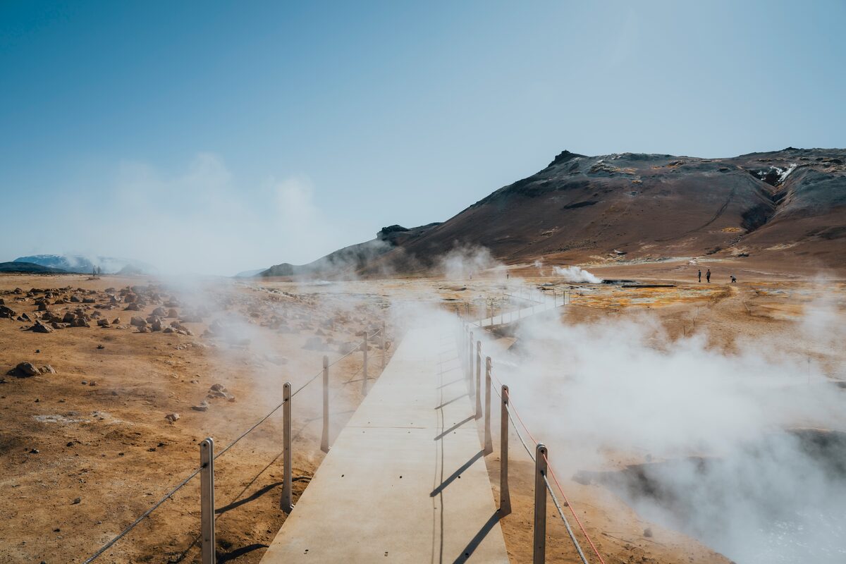 Steam rising from orange and yellow mud pots at the Hverir geothermal area.