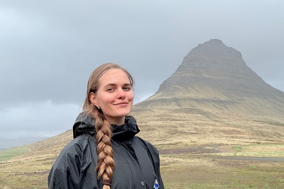 Anhelina with the cone-shaped Kirkjufell mountain rising behind her in West Iceland.