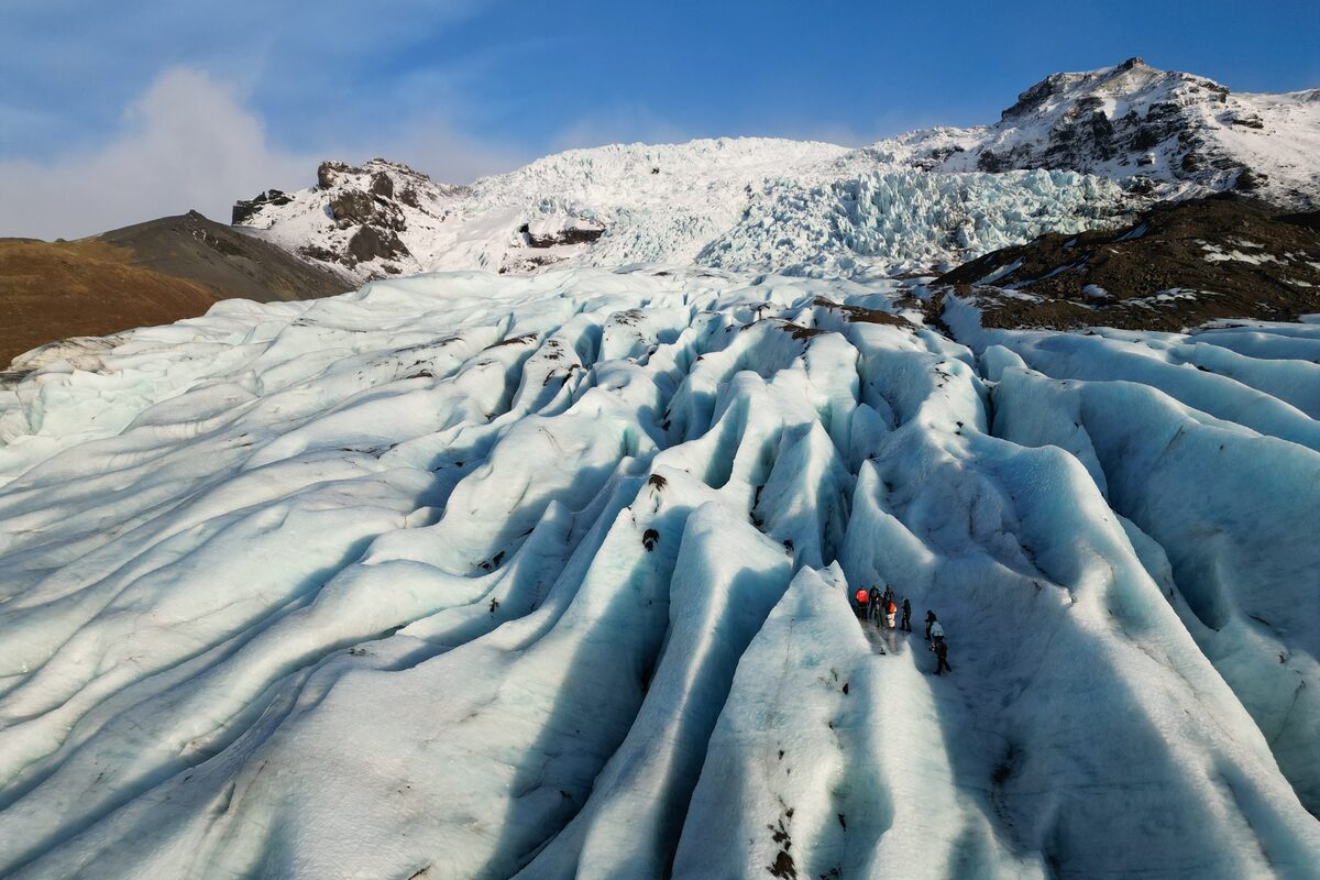 Glacier Crevasses In Comparison With A Group Of People in Iceland