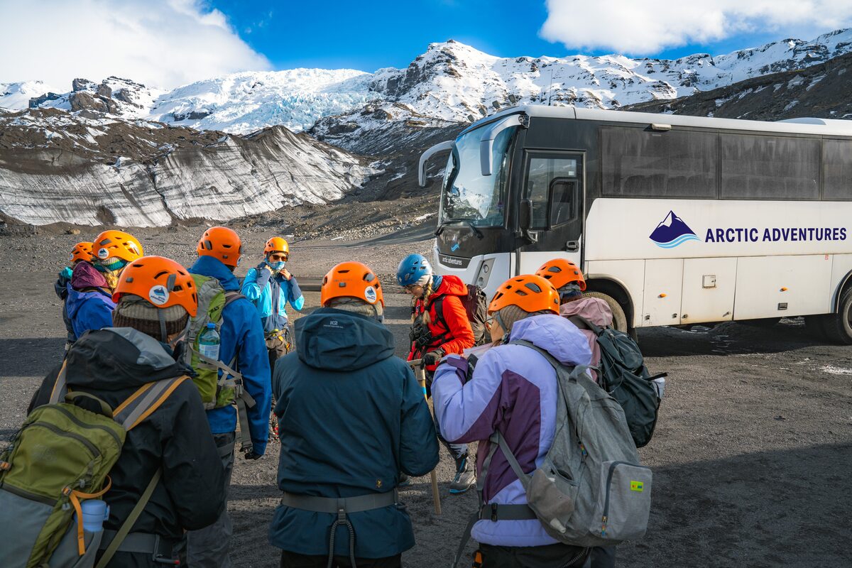 Group Of People Near A Bus Getting Ready For A Glacier Hike in Iceland