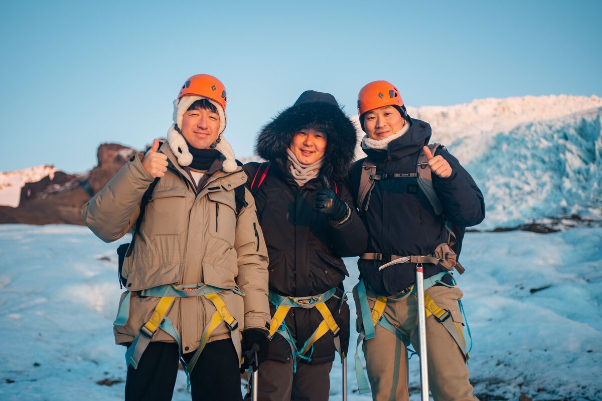 Three Asian Men In Harnesses On A Glacier in Iceland