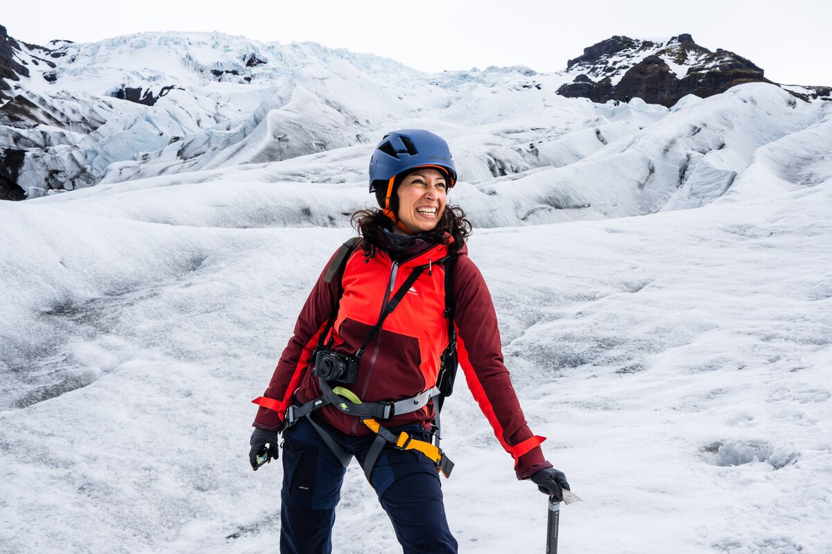 Woman In A Red Jacket On A Glacier Smilling in Iceland