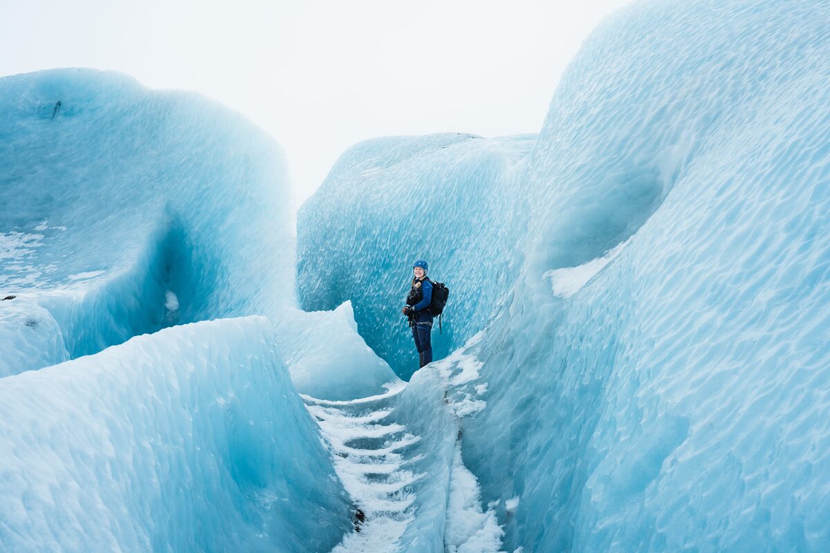 Woman Standing In Between Glacier Crevasses in Iceland
