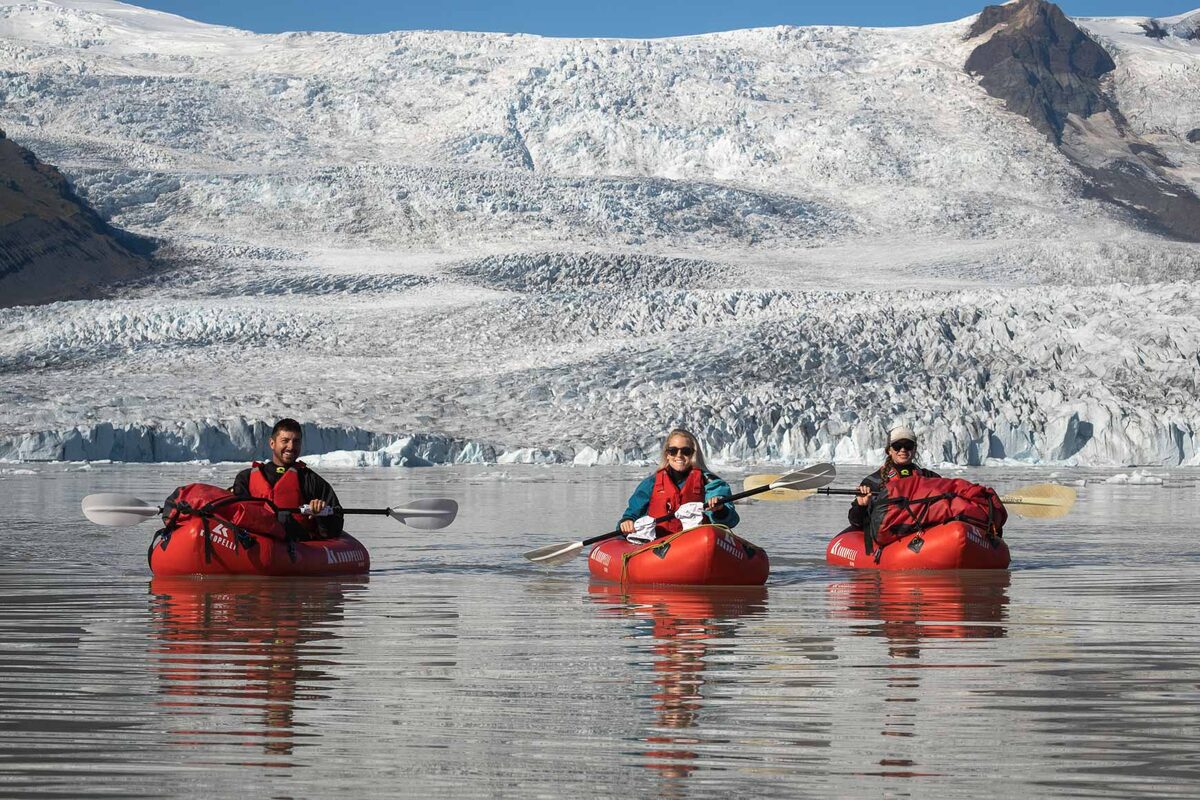 People In Three Red Kayaks In The Fjallsarlon Glacier Lagoon in Iceland