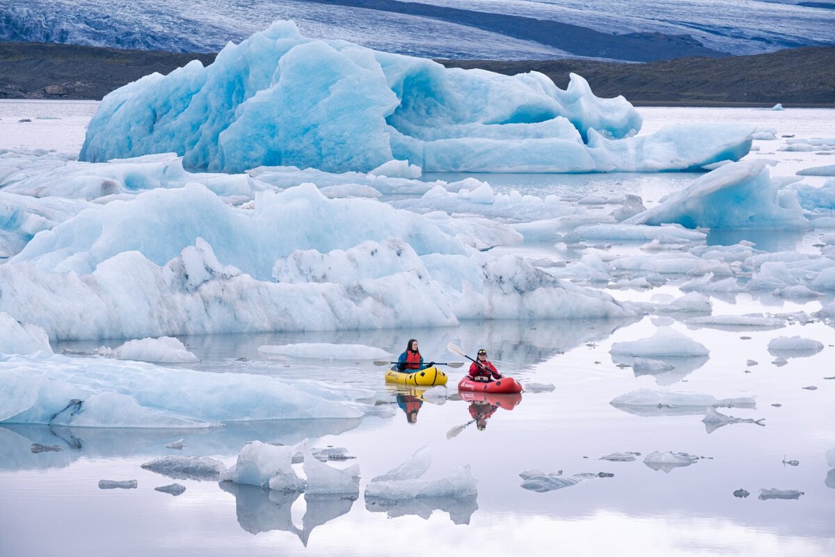 Women In Kayaks With Ice Formations Around Them in Iceland