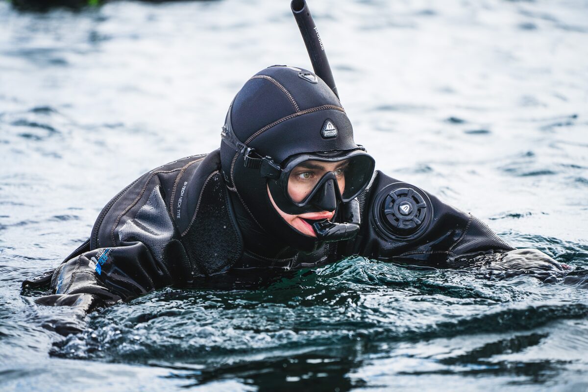 Woman In A Full Wet Suit And Snorkel In Water in Iceland