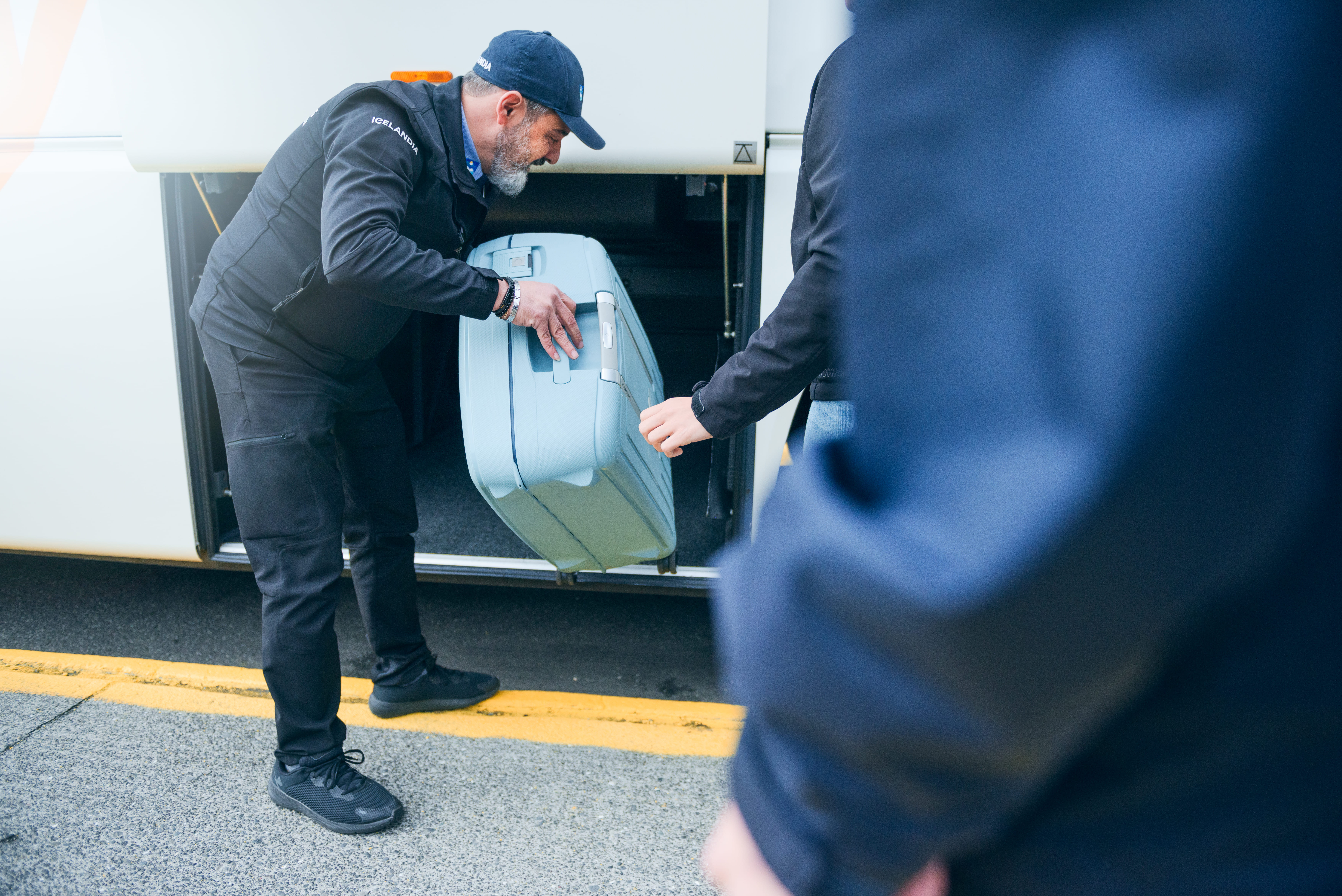 Bus Driver Helping People Put Their Bags In The Bus in Iceland