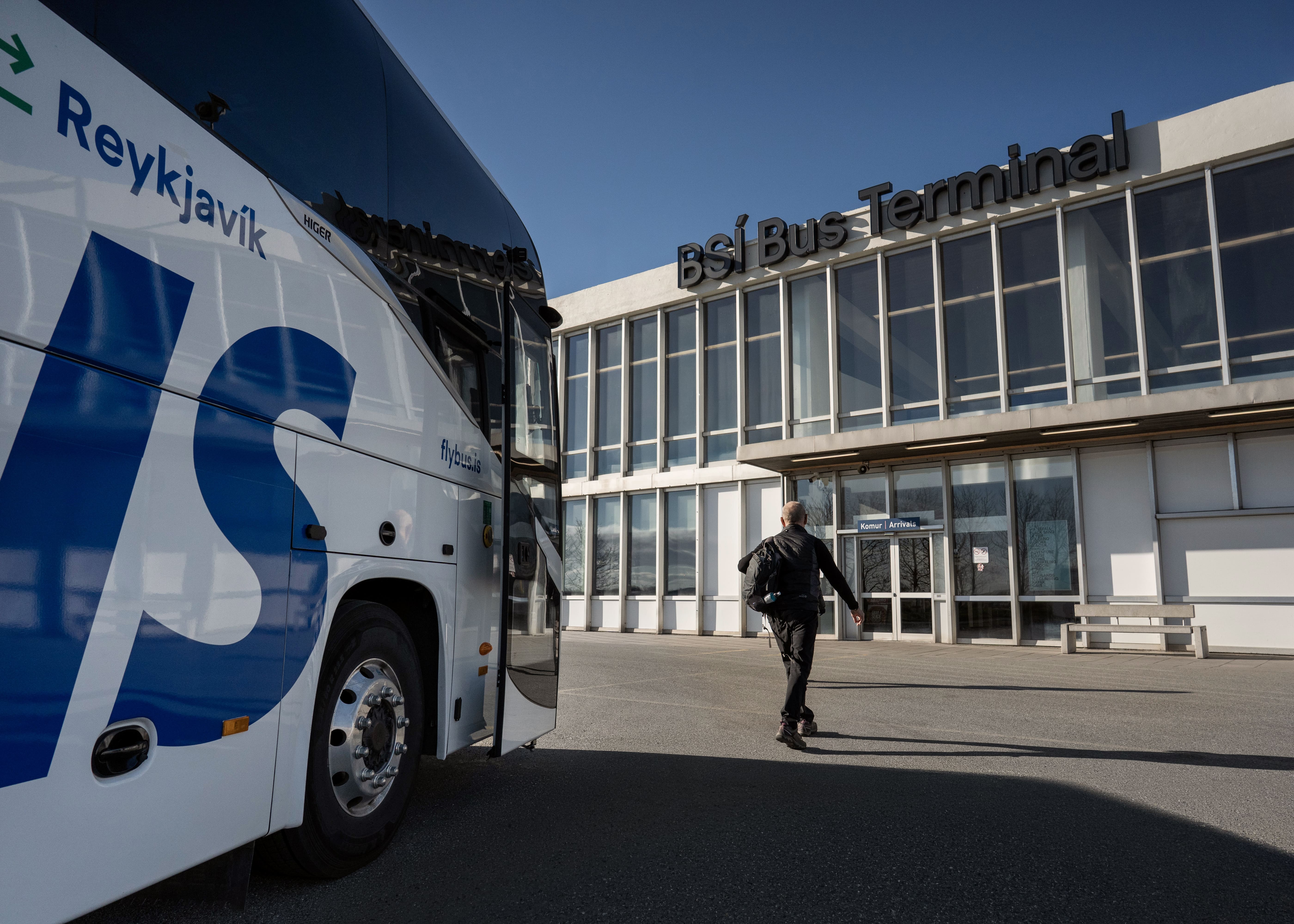 Man Walking From A Bus To The Airport Entrance in Iceland
