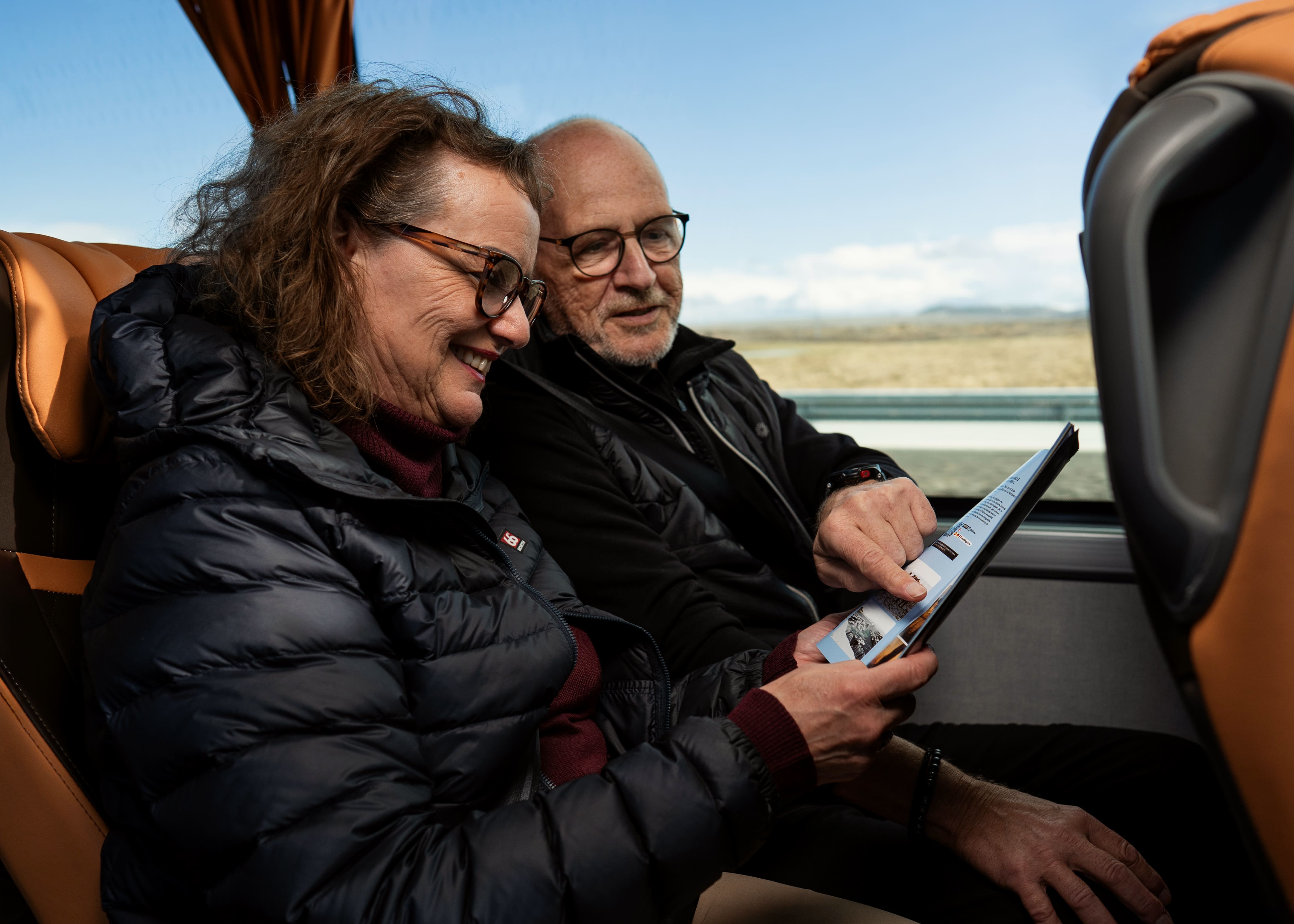Senior Couple Sitting In The Flybus Bus And Reading A Brochure in Iceland