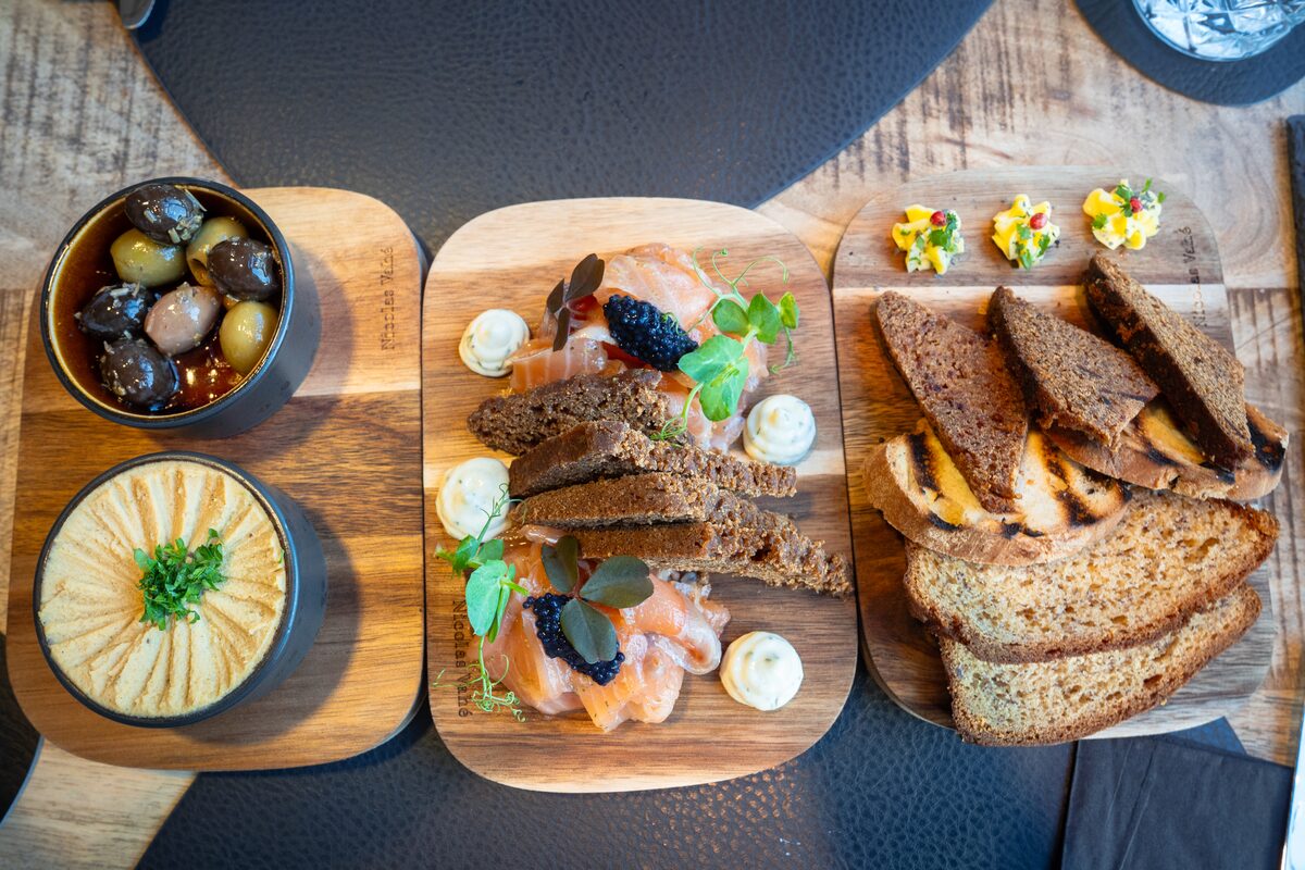 Wooden boards with rye bread, salmon, spreads, and small dishes at MÚRAL restaurant in Hellissandur, West Iceland.