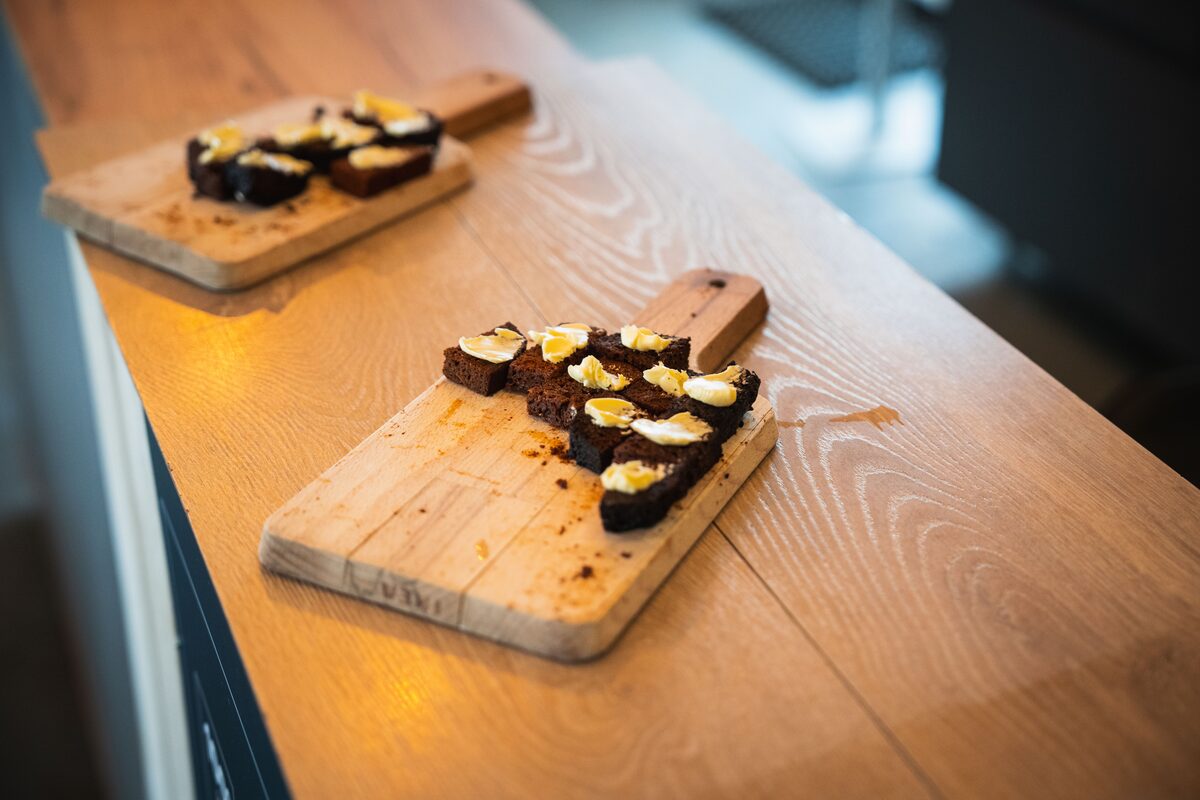 Slices of buttered dark rye bread on wooden boards at Sturlureykir farm, West Iceland.