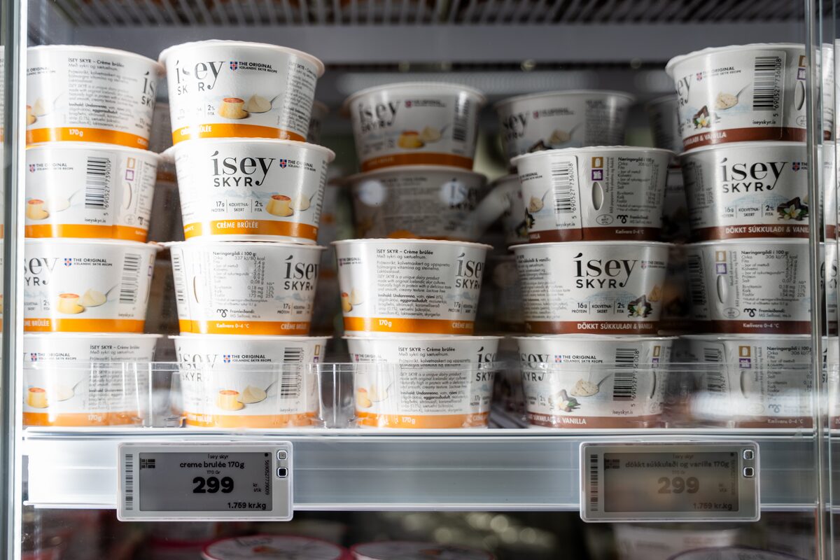 Tubs of Ísey Skyr stacked in a refrigerated Icelandic supermarket case.