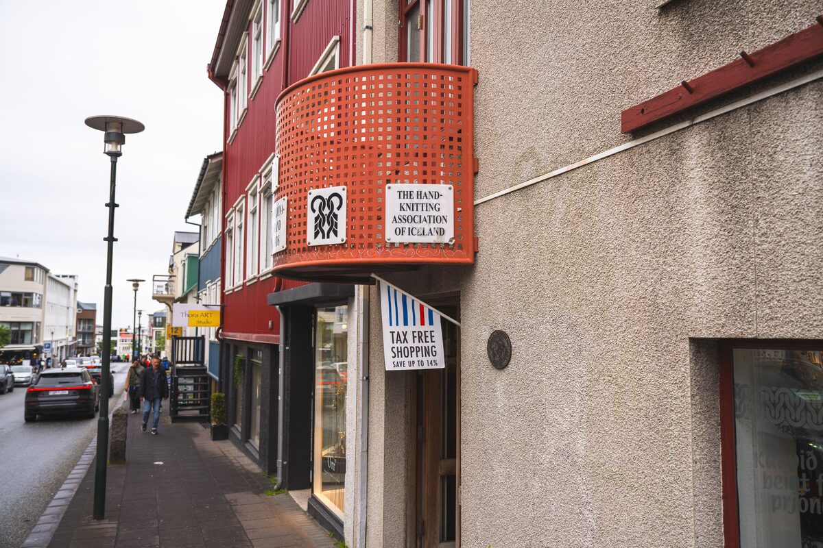The Hand-Knitting Association of Iceland's storefront with a curved orange balcony.