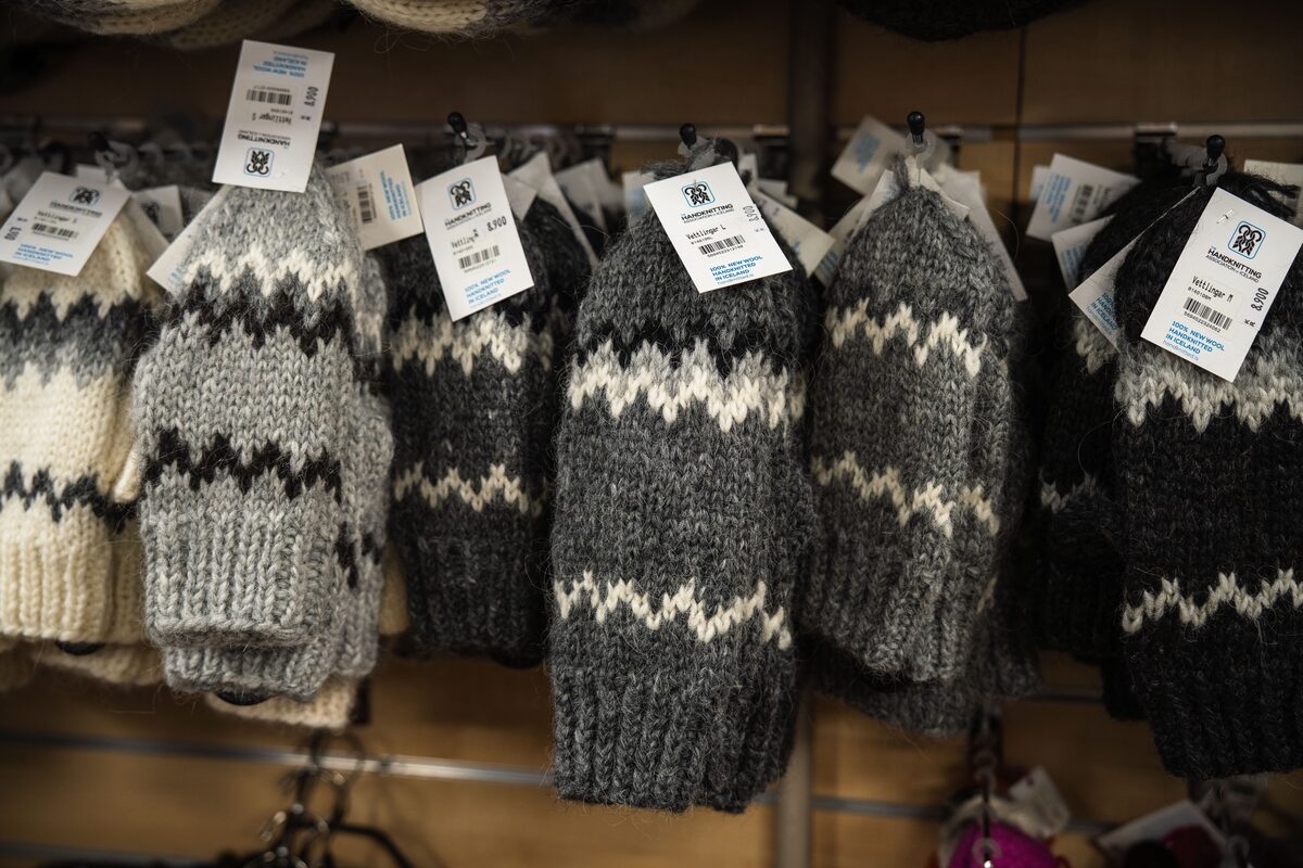 Hand-knit wool mittens with price tags on display at the Hand-Knitting Association shop.