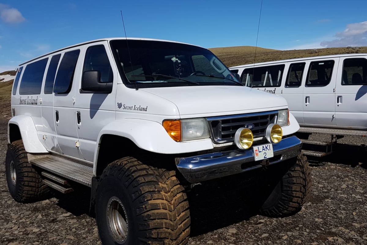 Two white Secret Island super jeeps parked.