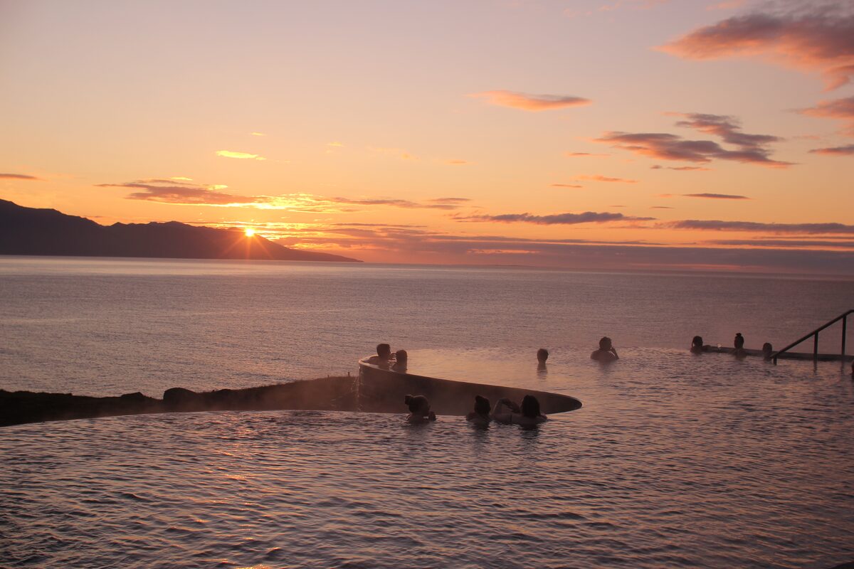 People In Geosea Hot Springs At Sunset in Iceland