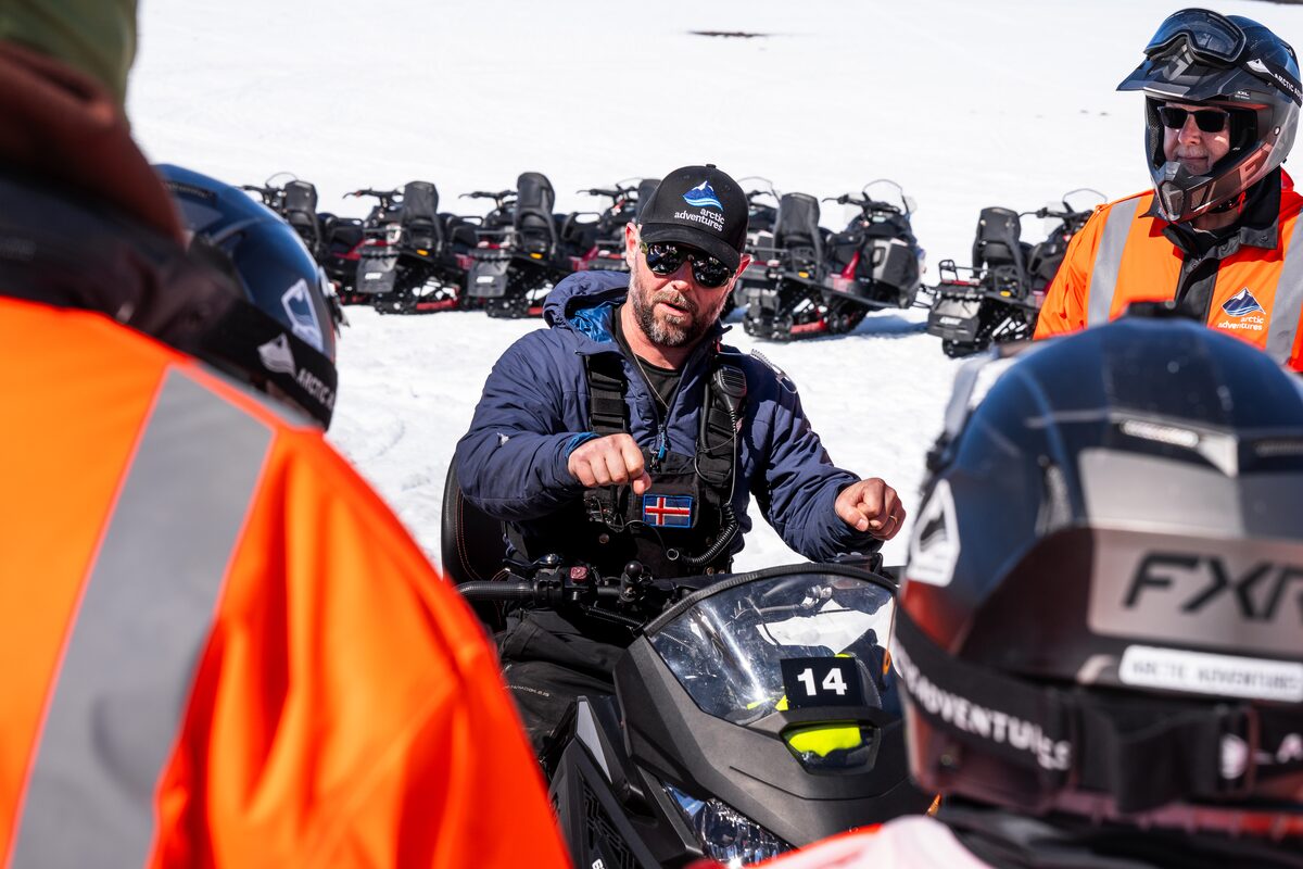 Arctic Adventures glacier guide instructing small snowmobiling group in Langjokull glacier.