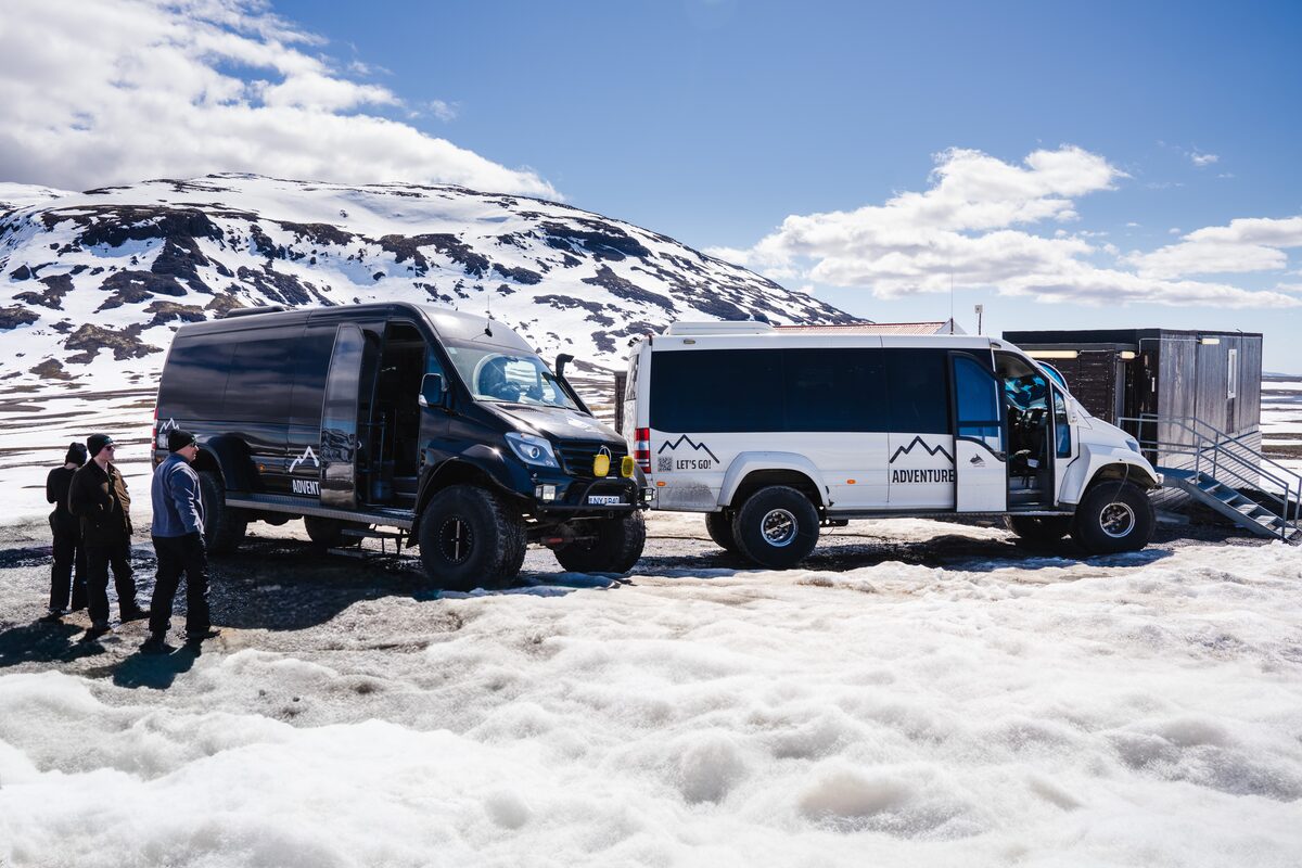 Two Arctic Adventures super jeeps parked at Langjokull glacier with views of glacier mountains.