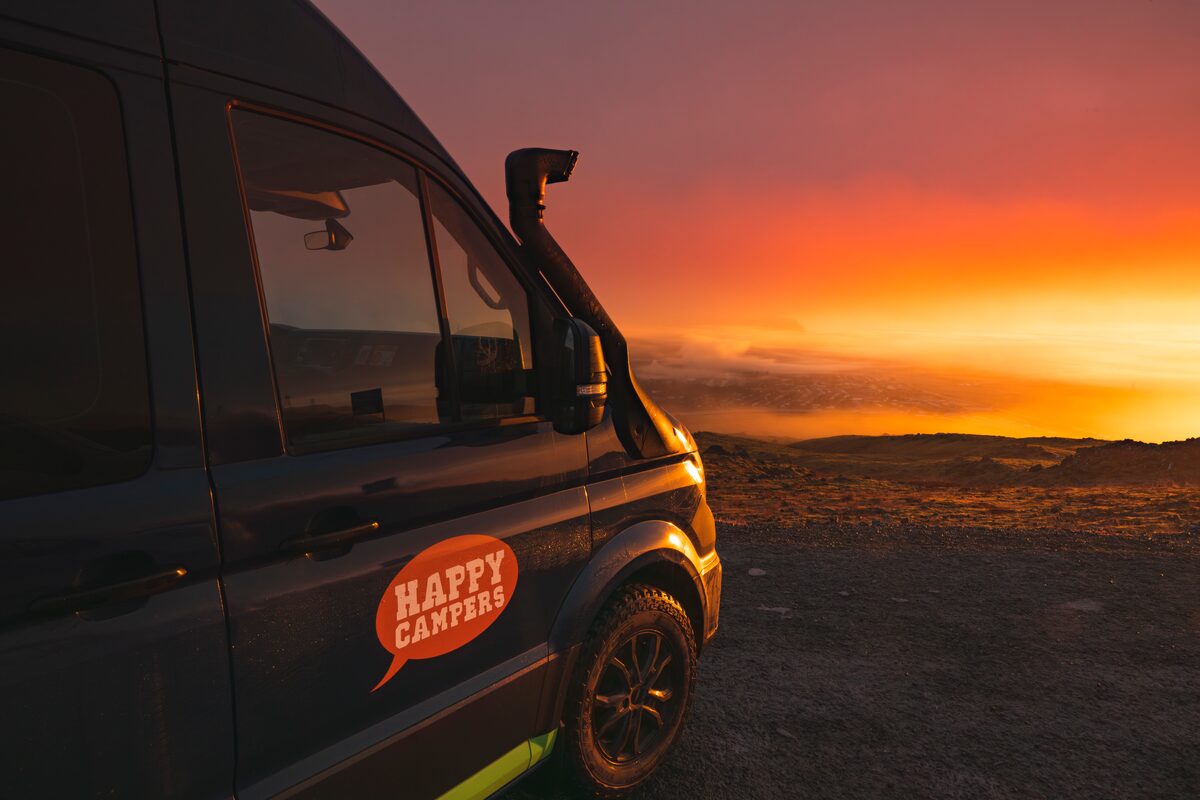 View of front of campervan parked in golden sunset in Iceland.