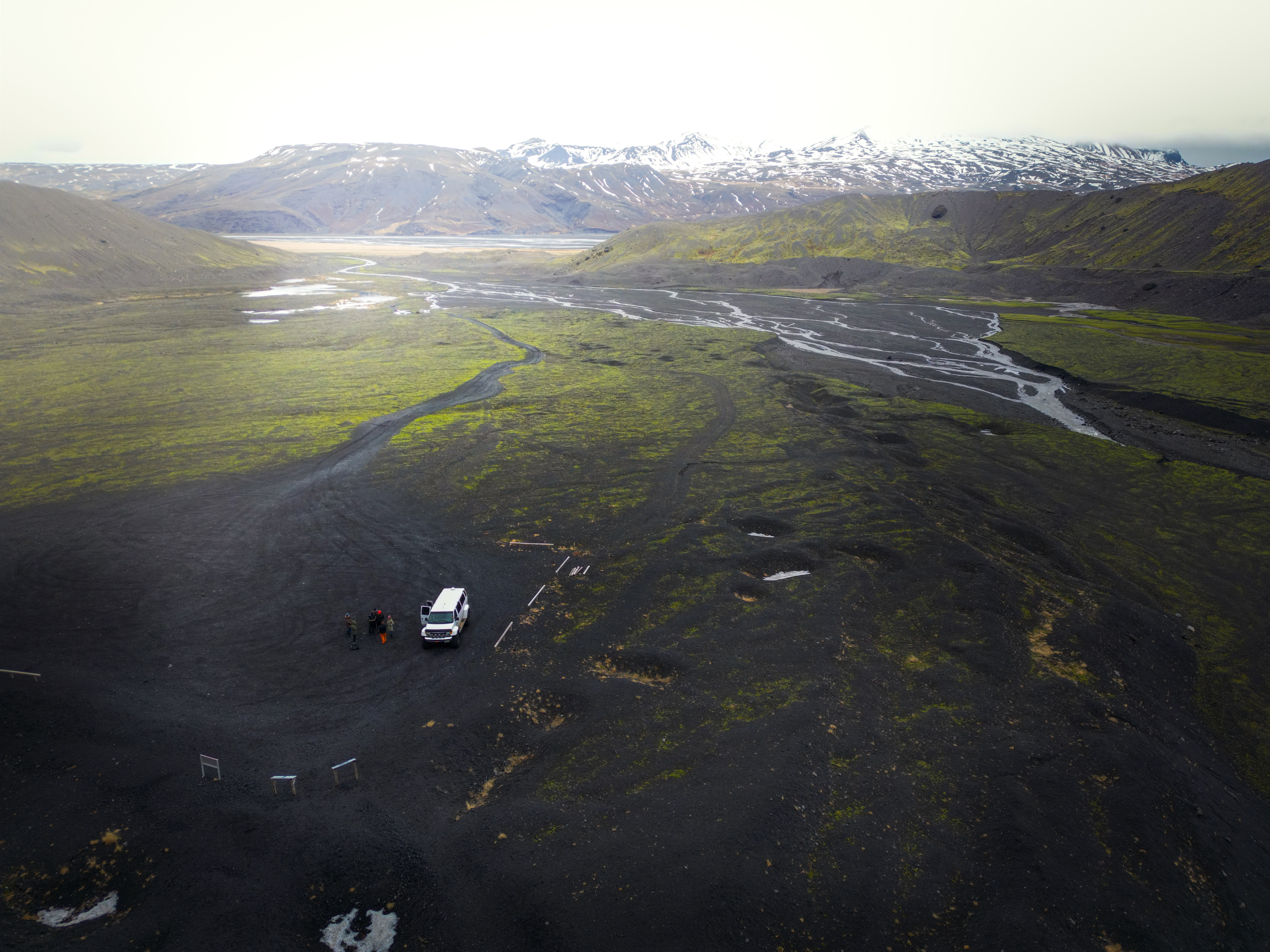 Super Jeep Parked With People Nearby And Big Mountains In The Background in Iceland