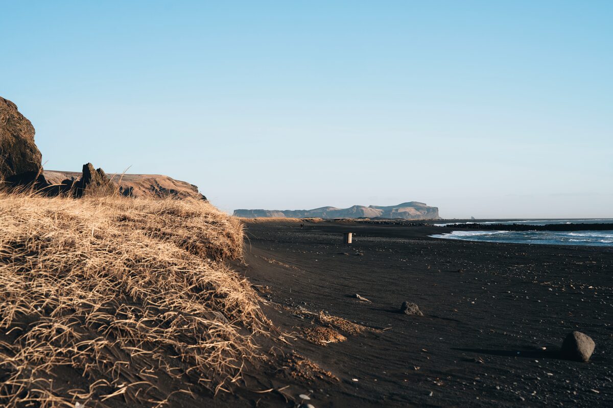 Dark sand plain below Hjörleifshöfði in low midnight sun light.