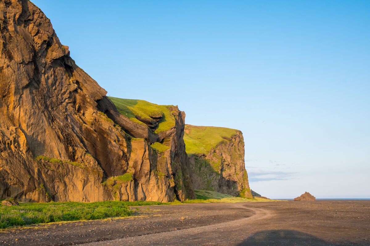 Layered tuff cliffs on the side of Hjörleifshöfði.