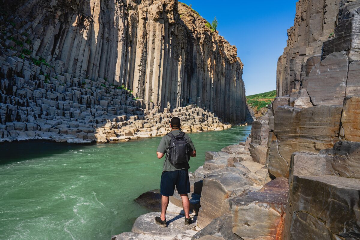 Man Standing On The Edge Of Studlagil Canyon Near Water in Iceland
