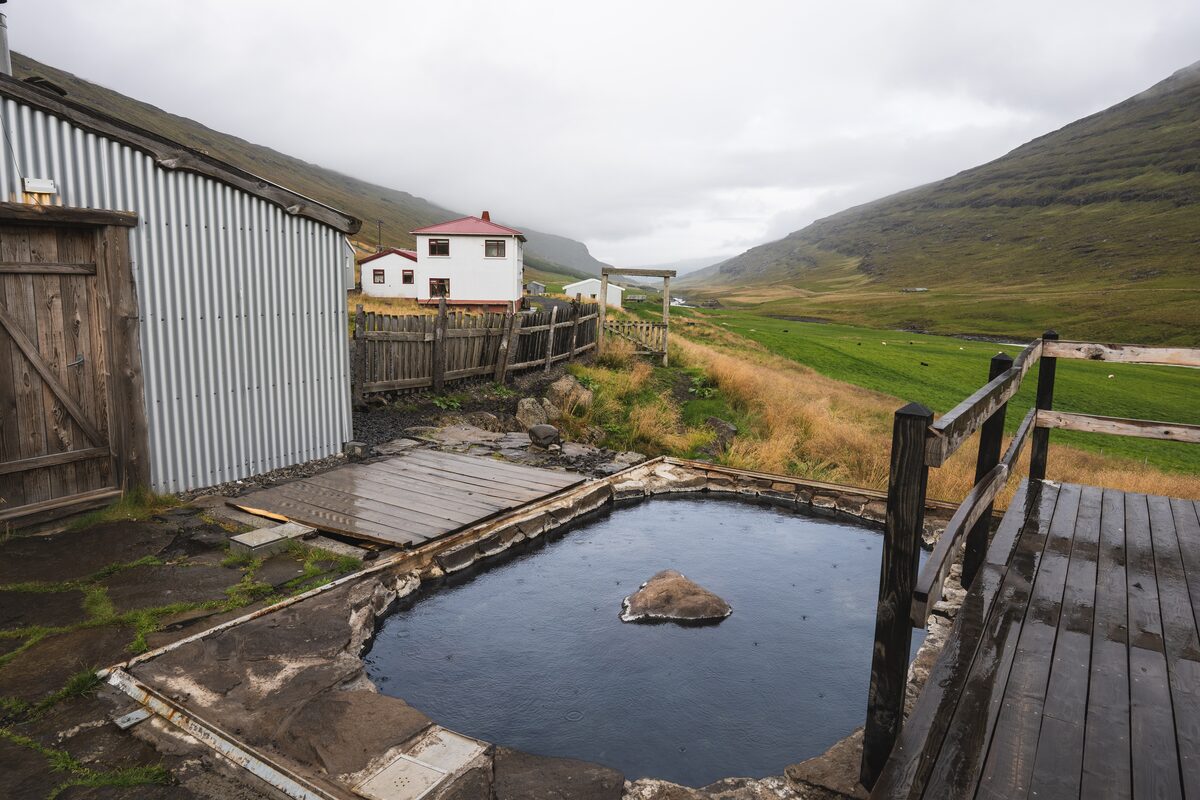 Stone-lined outdoor pool beside wooden decks and farm buildings at the Wilderness Center.