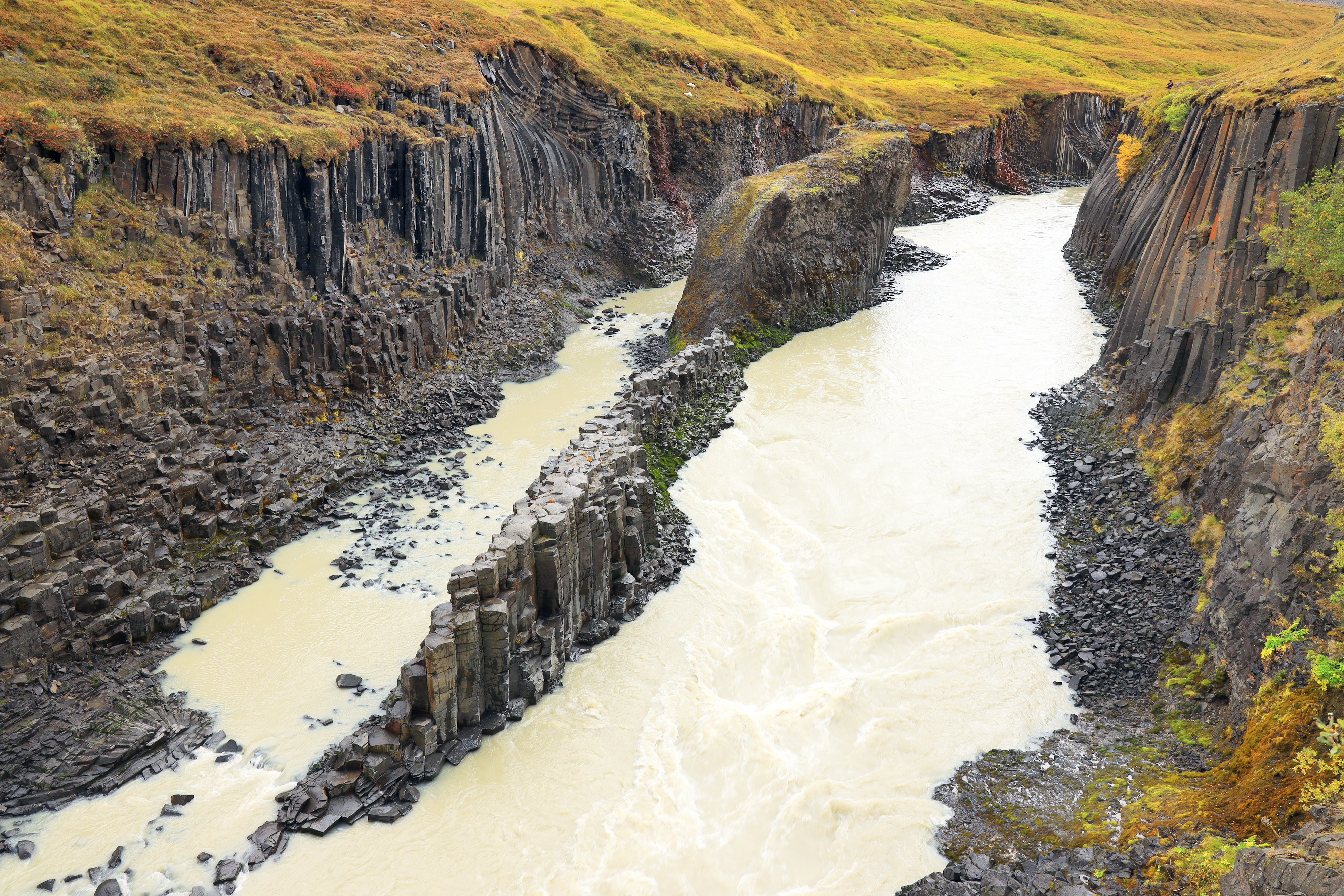 Gray-brown Jökla river flowing through Stuðlagil canyon