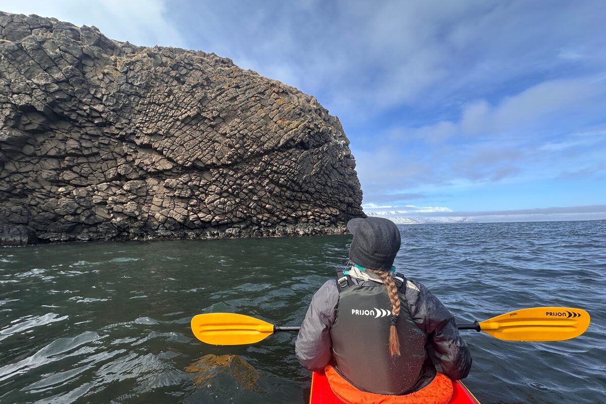 People In A Red Kayak Looking At Basalt Columns in Iceland