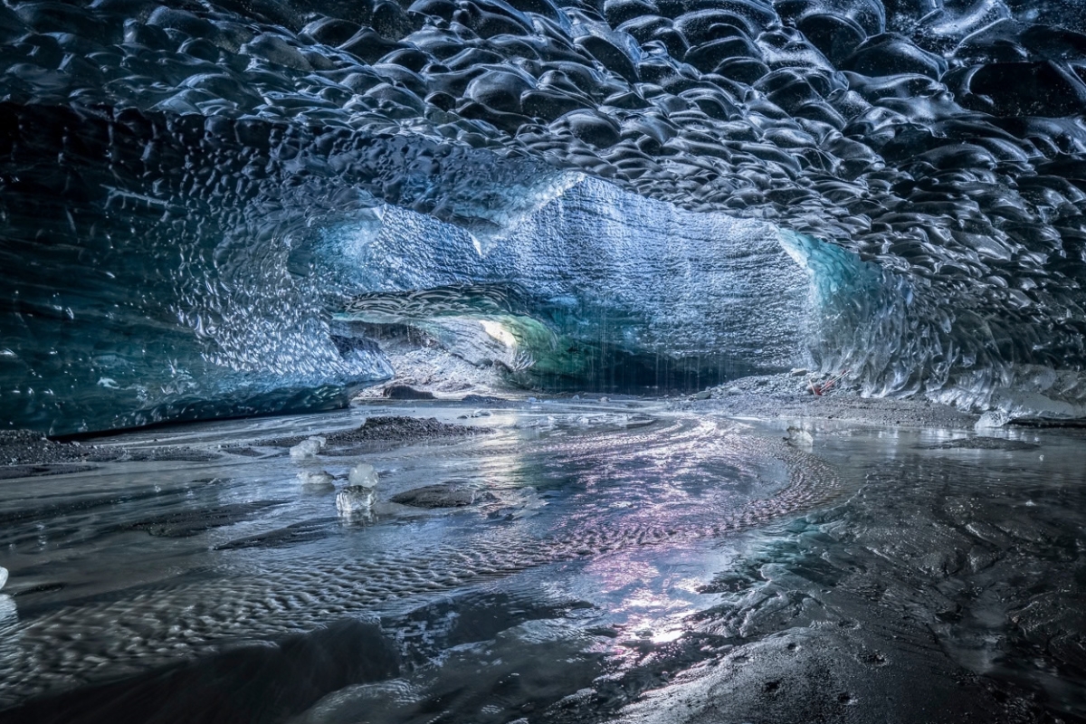 Stunning inside of crystal ice cave, ice cave walls reflecting the light.