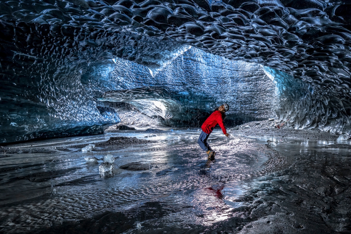 Person posing for photograph inside Crystal ice cave, in Iceland 2026.