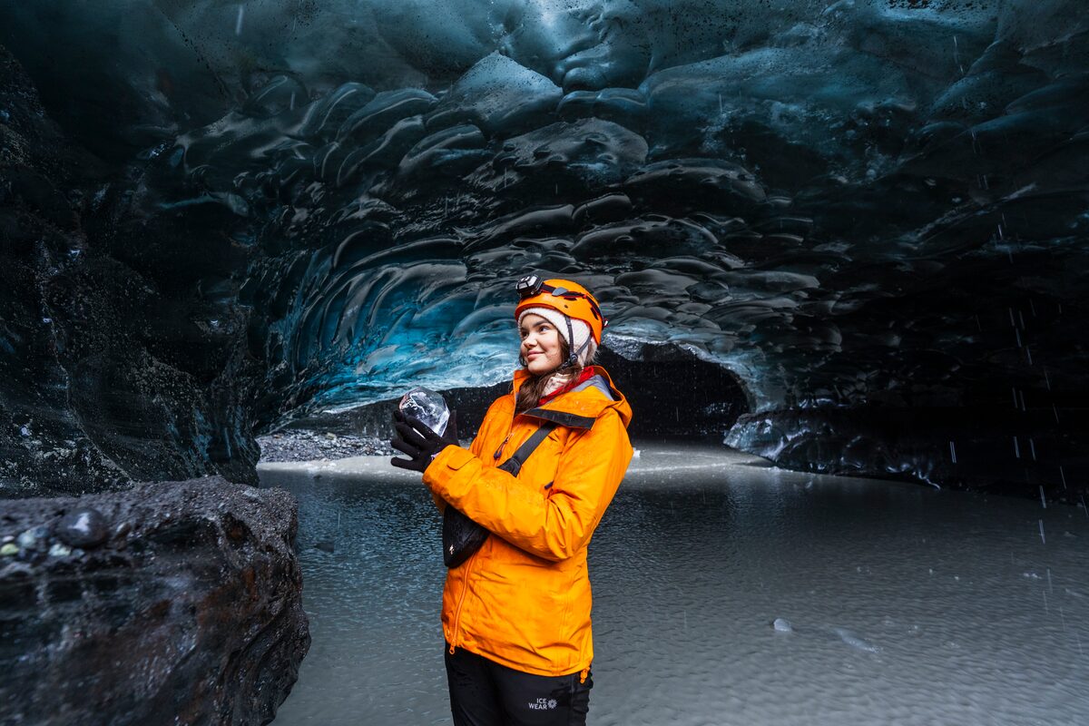 Female Tourist Holding Ice Inside Crystal Ice Cave