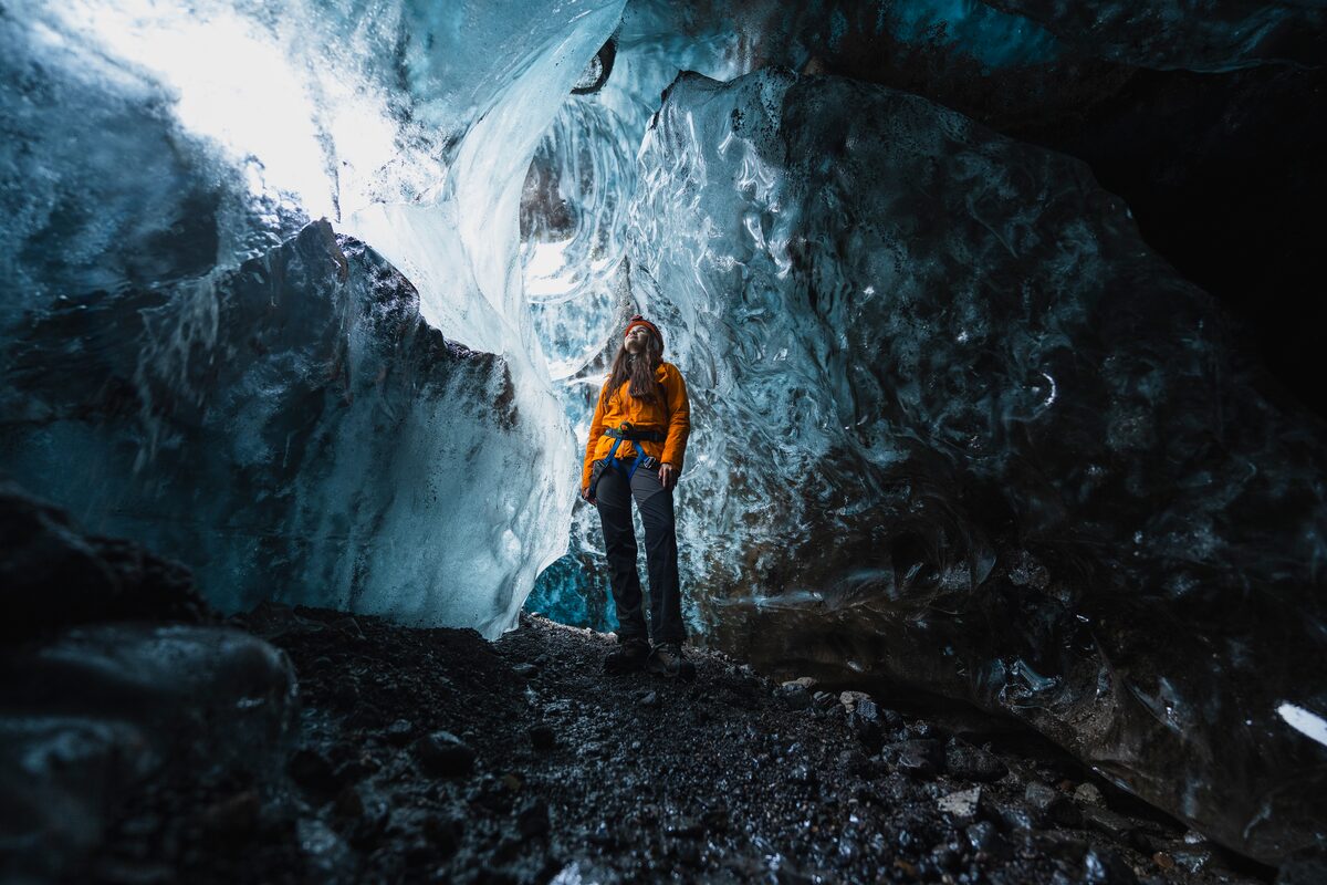 Woman In A Blue Ice Cave Standing Between Icy Walls in Iceland