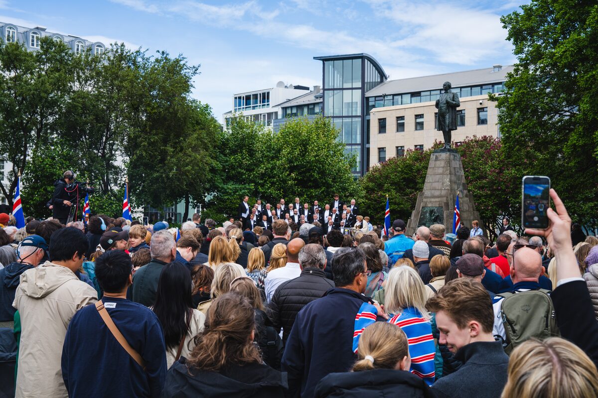 Crowd gathered around Jón Sigurðsson's statue at Austurvöllur on National Day in Reykjavík.