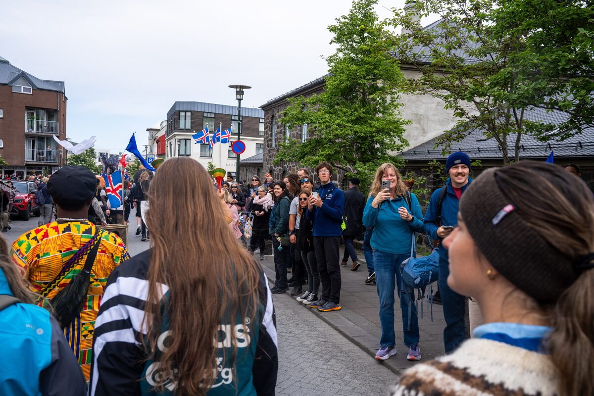 Crowds line a Reykjavík street as people carrying Icelandic flags pass during National Day celebrations.