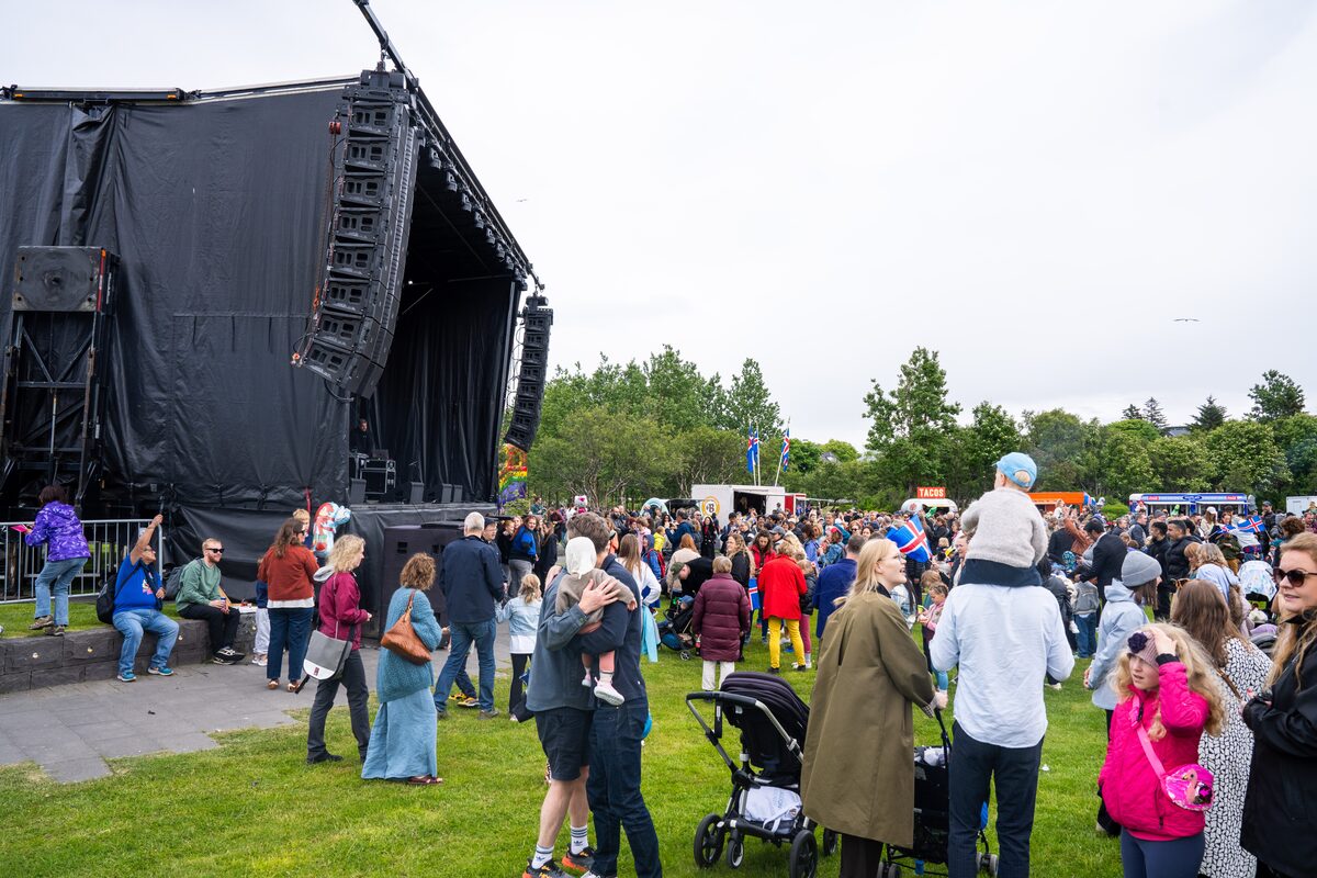 Crowd beside an outdoor stage in Hljómskálagarður park during Reykjavík's National Day celebrations.