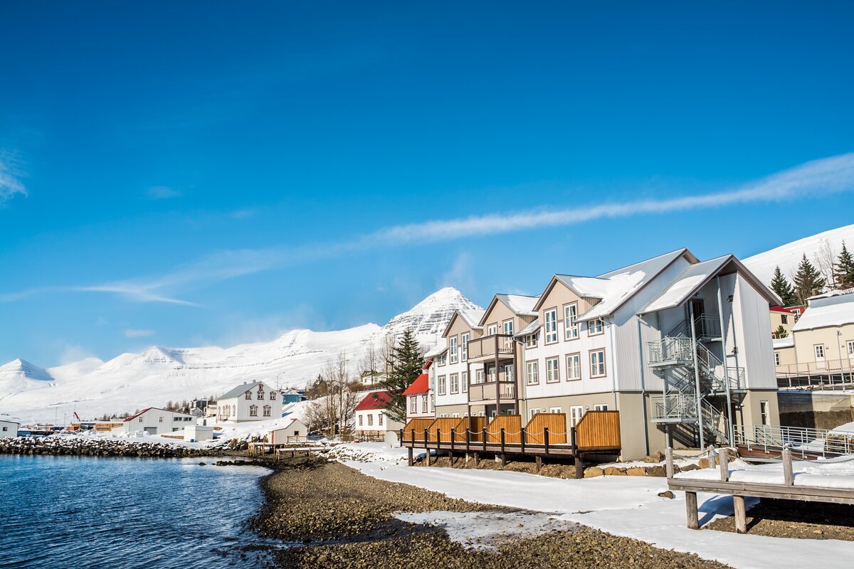 Snow-covered shoreline and mountains in Seyðisfjörður, winter.