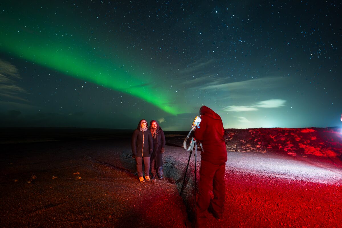 Two Women Posing For An Image Under Northern Lights in Iceland