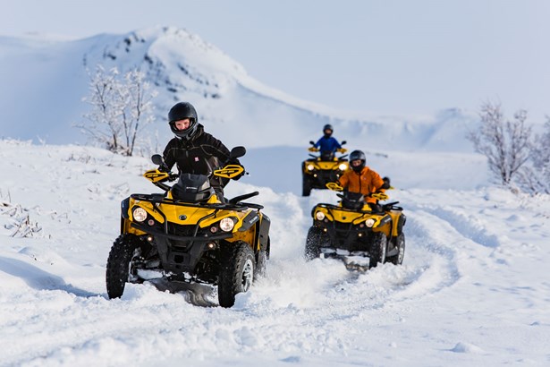 group driving ATVs in extreme weather