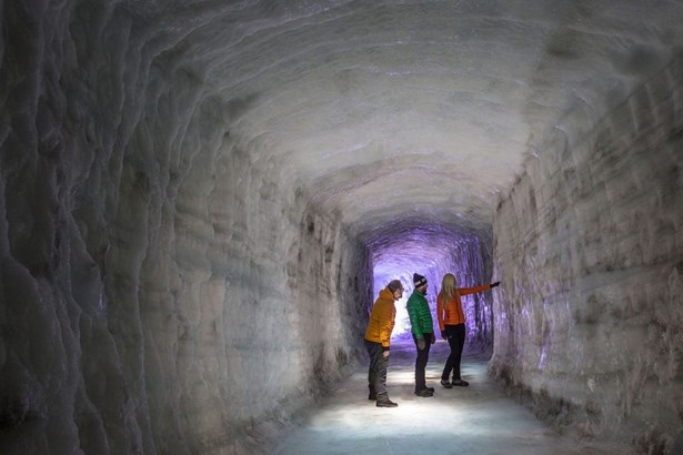 people exploring the ice cave tunnel