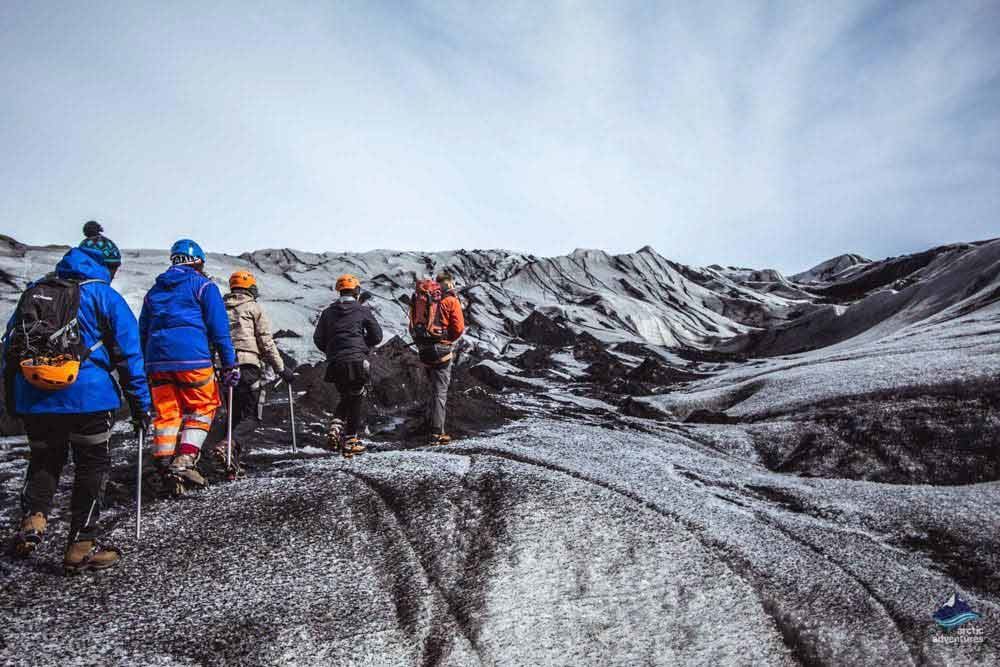 people glacier hiking on black ice