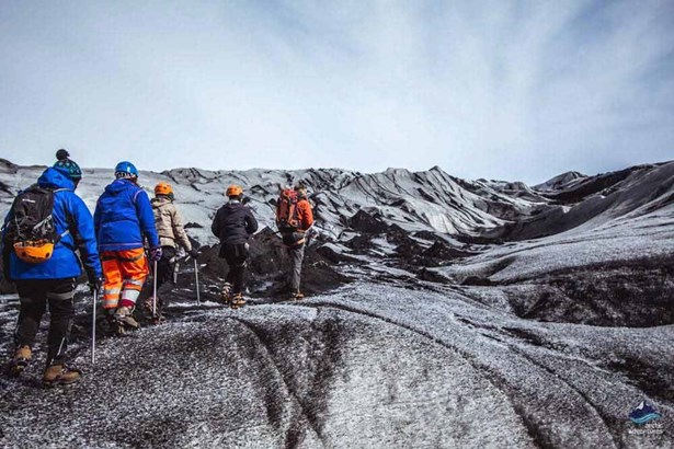 people glacier hiking on black ice in Iceland