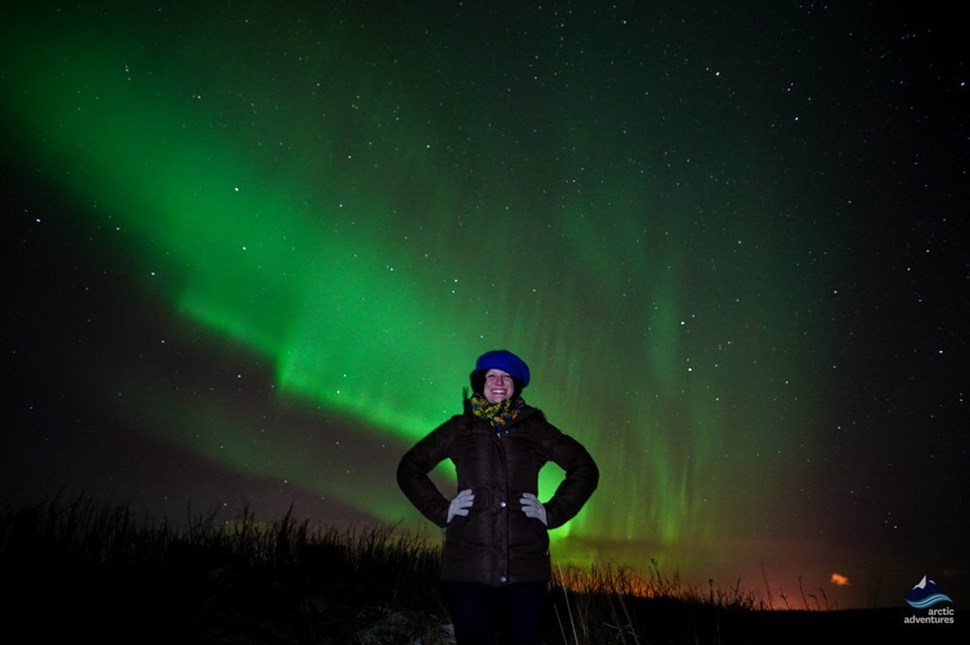 happy woman at night under Northern Lights