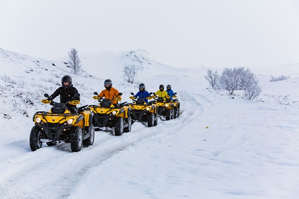group driving quad bikes on winter road