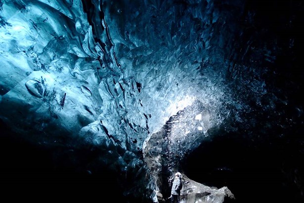 man inside ice cave during night